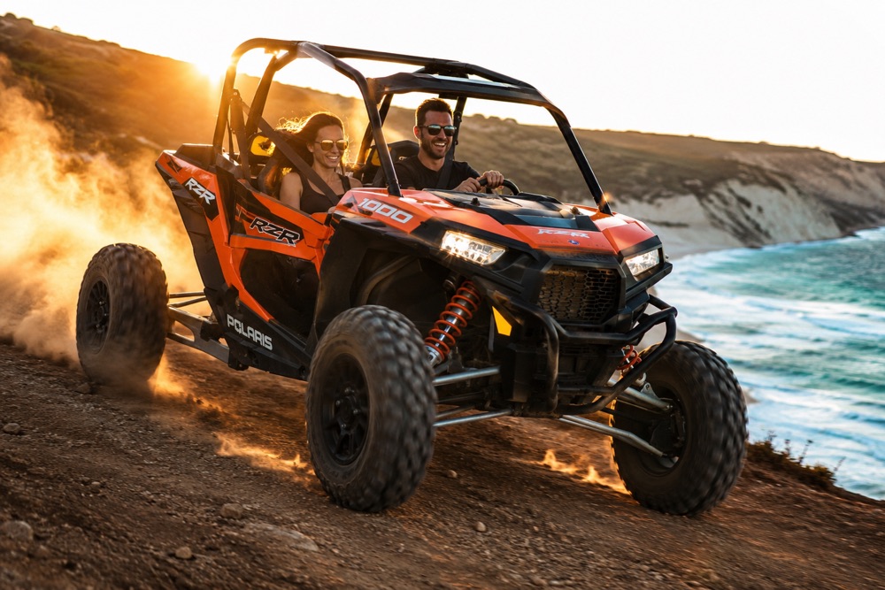 Couple in a red 2-seater buggy on a coastal track near Paphos